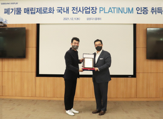 1일 삼성디스플레이 아산1캠퍼스에서 열린 폐기물 매립 제로 인증 수여식에서 최송천 삼성디스플레이 전무(왼쪽)와 정륜 UL코리아 대표가 기념사진을 촬영하고 있다. <삼성디스플레이 제공>